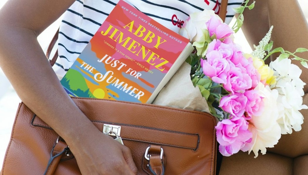 A girl holds a book in her purse