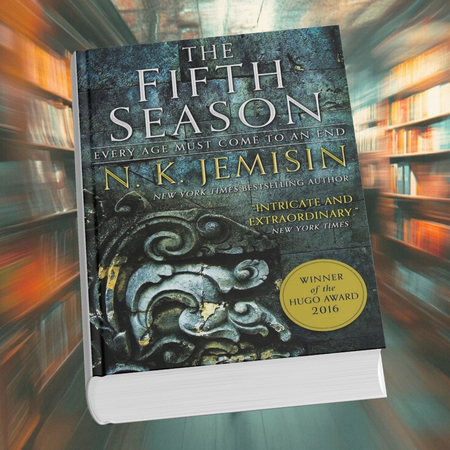 Cover of The Fifth Season by N.K. Jemisin with intricate stone carvings and a Hugo Award sticker, against a blurred library background